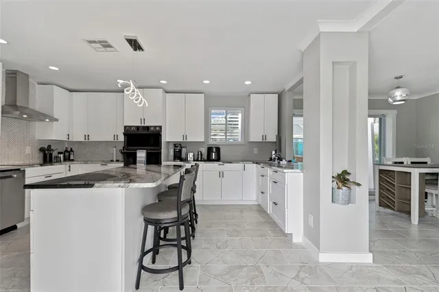 a kitchen with stainless steel appliances kitchen island granite countertop a sink and a stove
