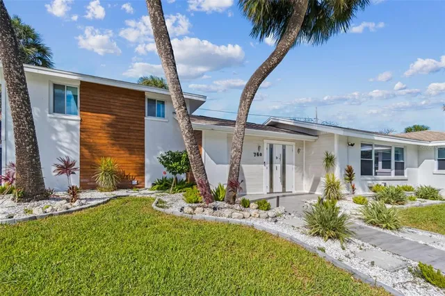 a front view of a house with a garden
