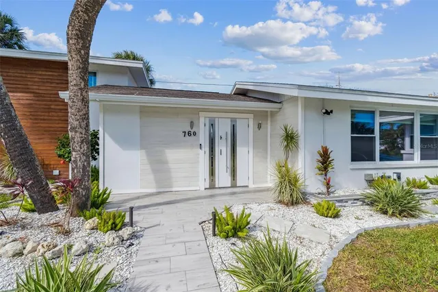 a kitchen with stainless steel appliances kitchen island granite countertop a table chairs sink and cabinets