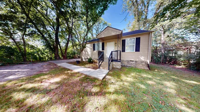 a view of a house with backyard and sitting area