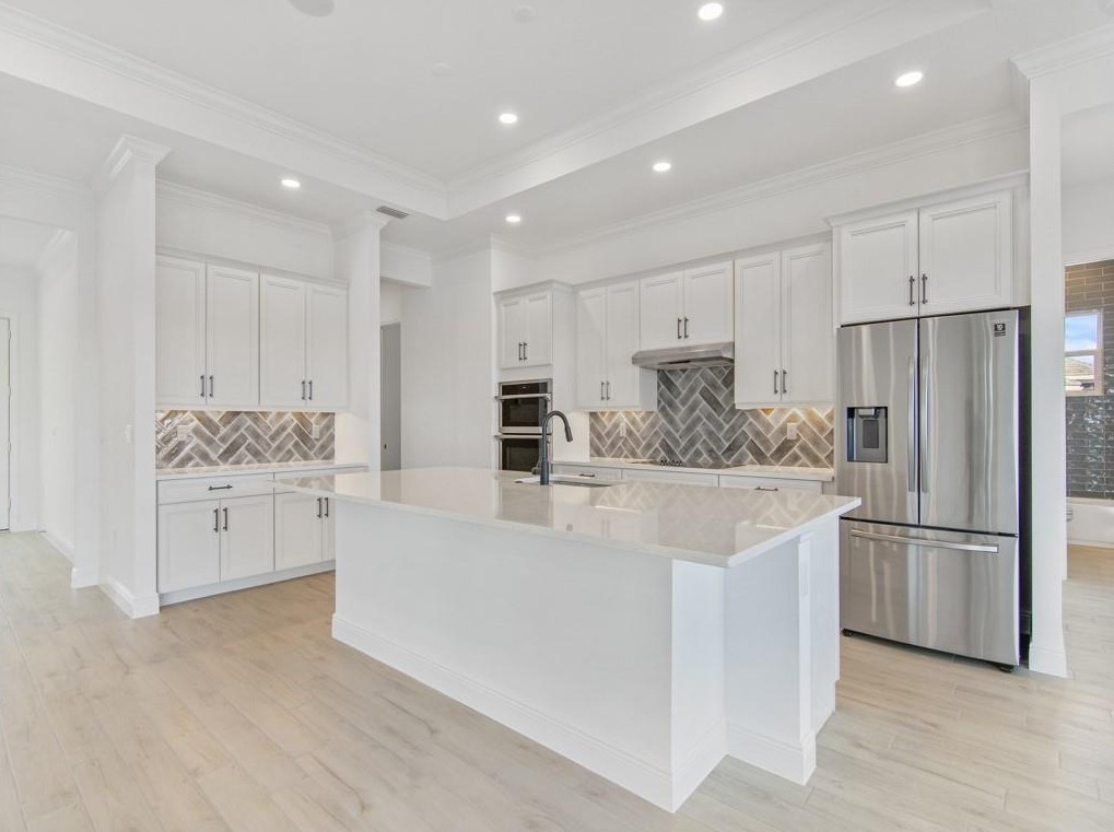5865 Palmetto Preserve Road Vero Beach, FL 32967 - Photo 5 of 7 a kitchen with white cabinets and white stainless steel appliances