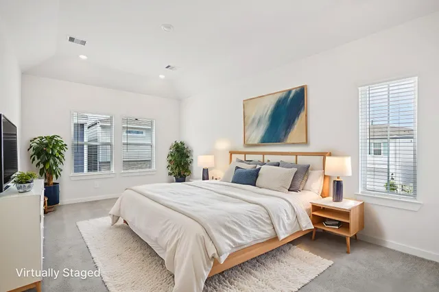 a bedroom with a bed and a large window