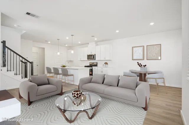 a living room with furniture kitchen view and a table