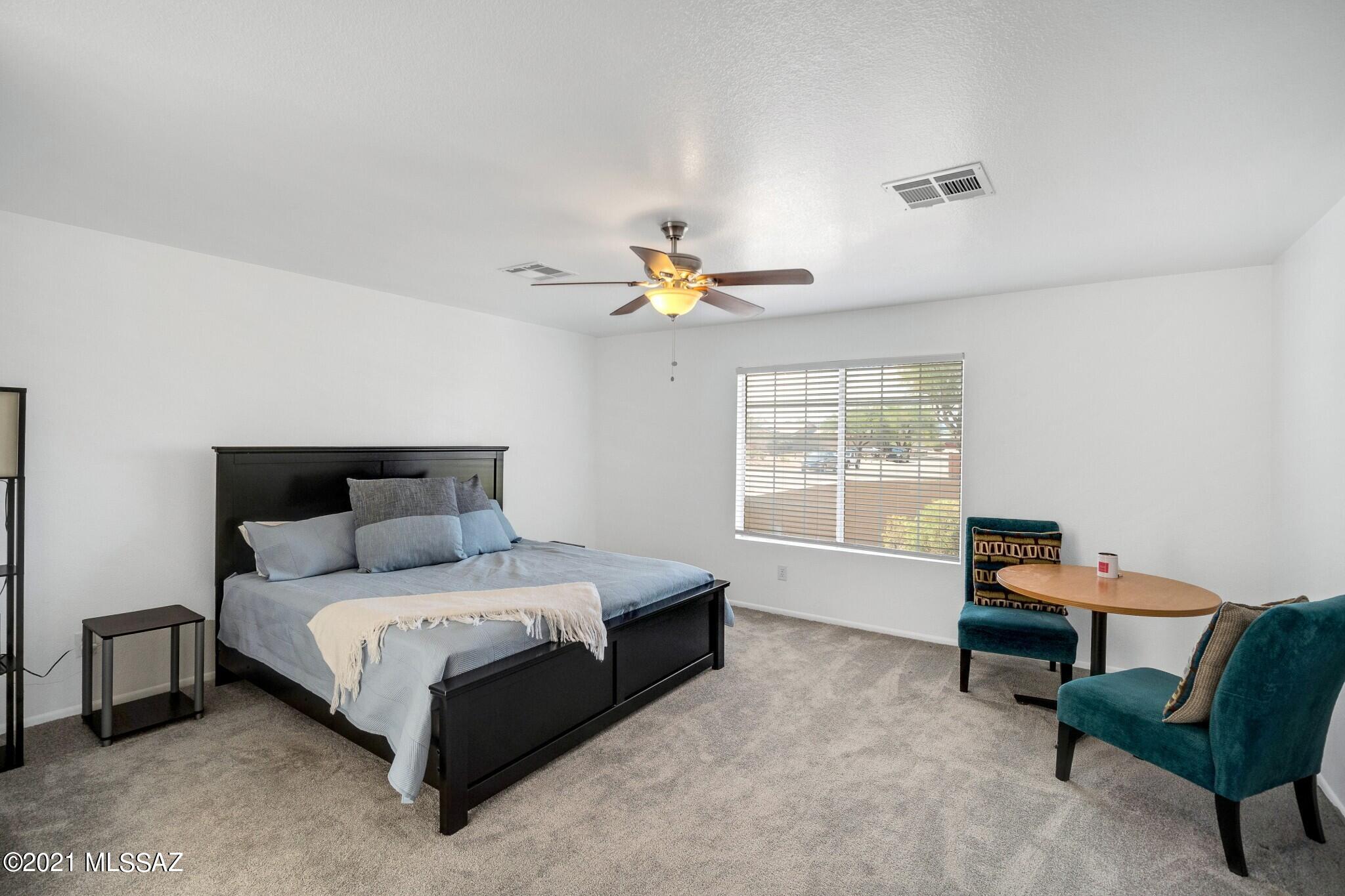 9671 East Azuma Way Tucson, AZ 85747 - Photo 13 of 31 a bedroom with a bed a chair and a window