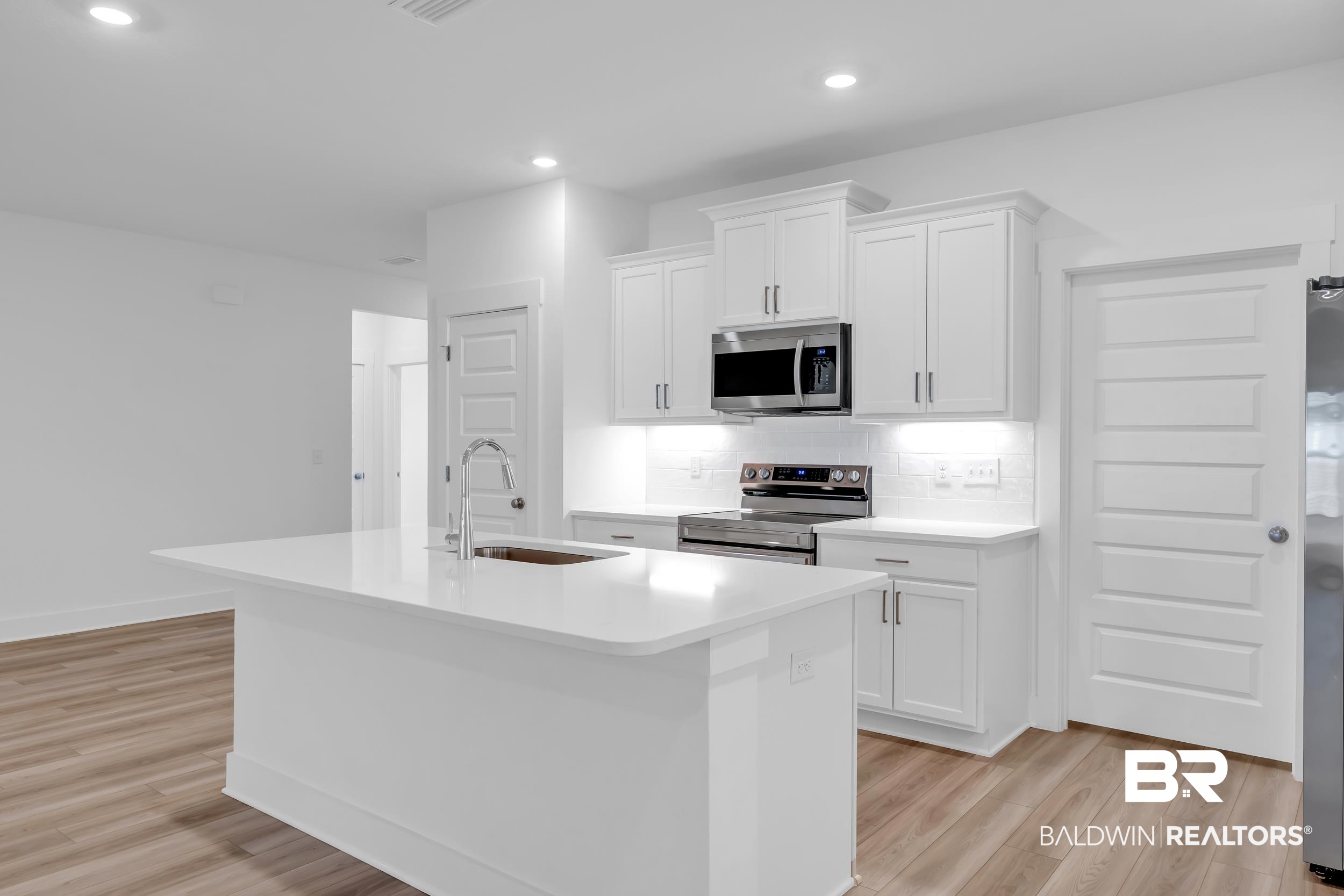 9933 Weller Cove Foley, AL 36535 - Photo 13 of 36 Kitchen featuring a large central island with an undermount sink and gooseneck faucet