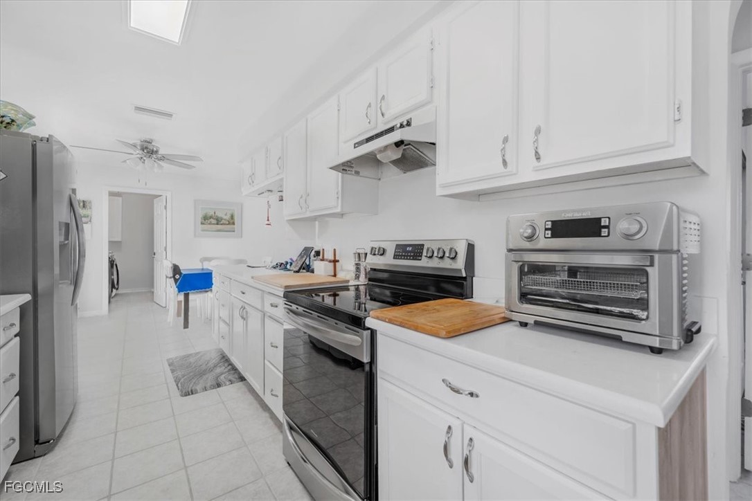 13239 Caribbean Boulevard Fort Myers, FL 33905 - Photo 14 of 37 a kitchen with stainless steel appliances granite countertop a stove a refrigerator and a white cabinets