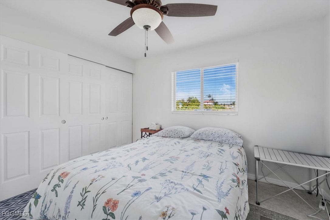 13239 Caribbean Boulevard Fort Myers, FL 33905 - Photo 17 of 37 a bedroom with a bed and a chandelier