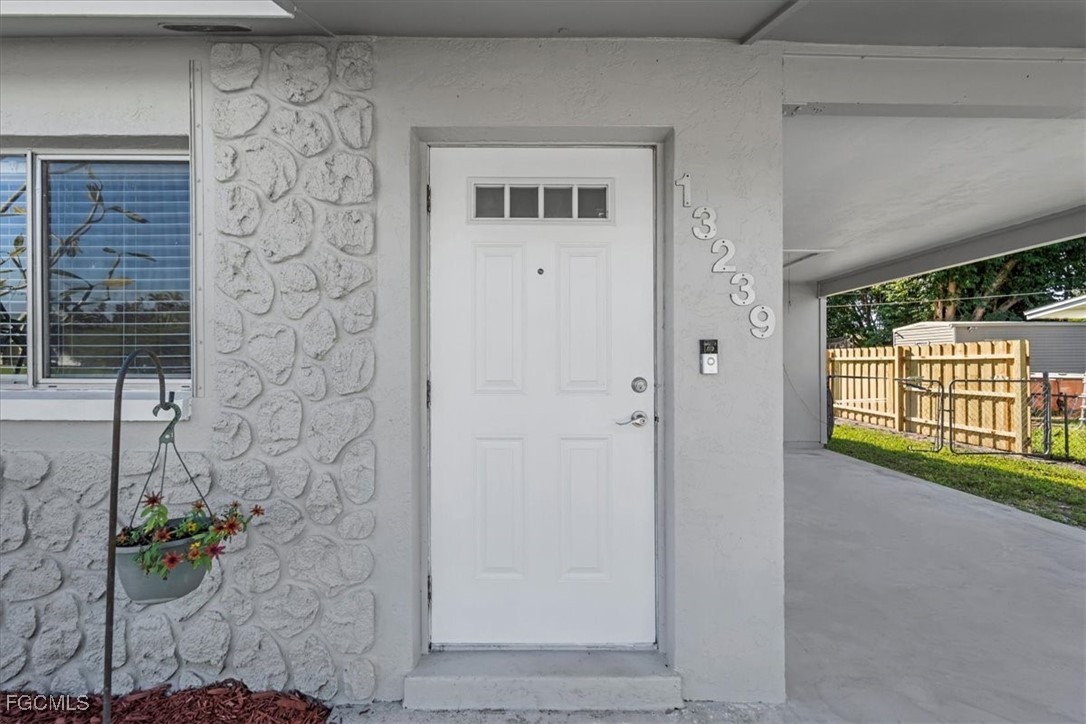 13239 Caribbean Boulevard Fort Myers, FL 33905 - Photo 4 of 37 a view of front door of house with a potted plant
