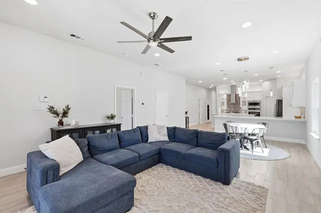 a living room with furniture kitchen view and a chandelier