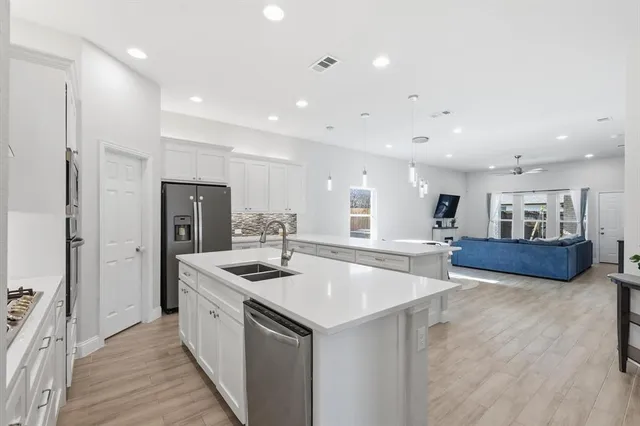 a kitchen with stainless steel appliances granite countertop a sink and a refrigerator