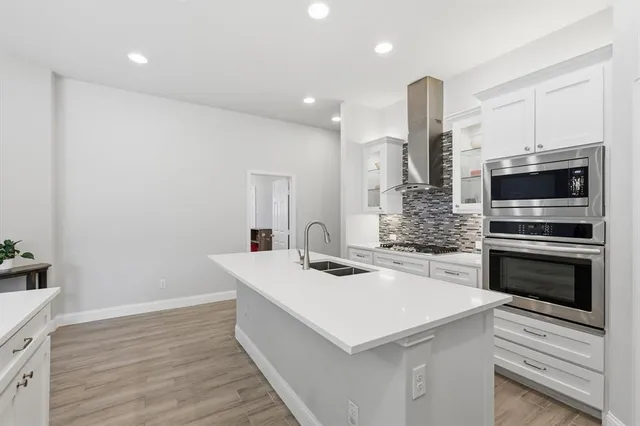 a kitchen with a sink a microwave and cabinets