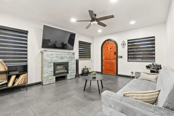 a living room with furniture a flat screen tv and a fireplace