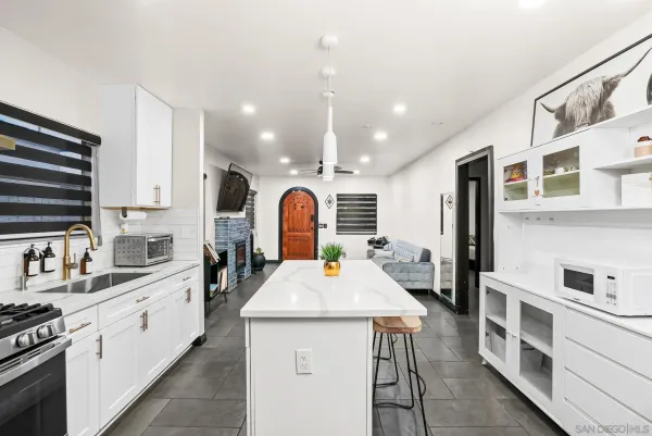 a large kitchen with sink a stove and cabinets