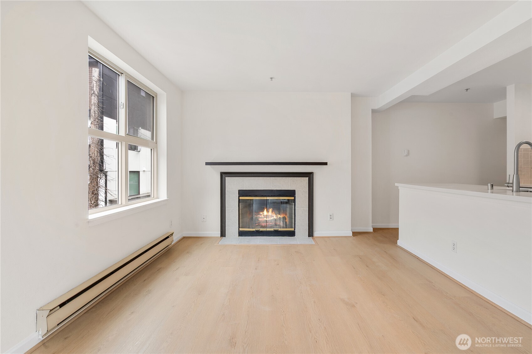 769 Hayes Street, Unit 405 Seattle, WA 98109 - Photo 11 of 29 a view of an empty room with a fireplace and a window