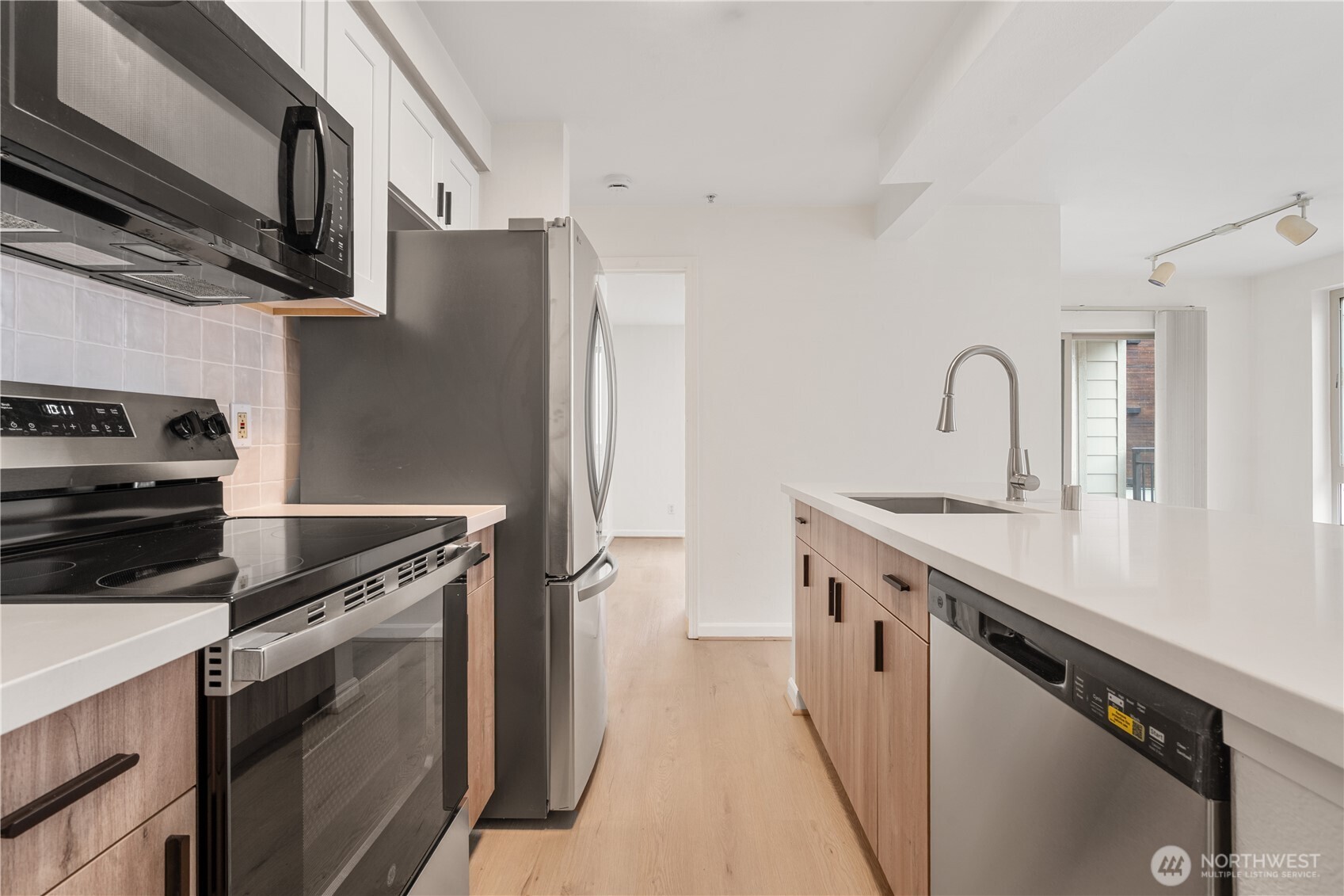 769 Hayes Street, Unit 405 Seattle, WA 98109 - Photo 5 of 29 a kitchen with stainless steel appliances granite countertop a sink stove and refrigerator