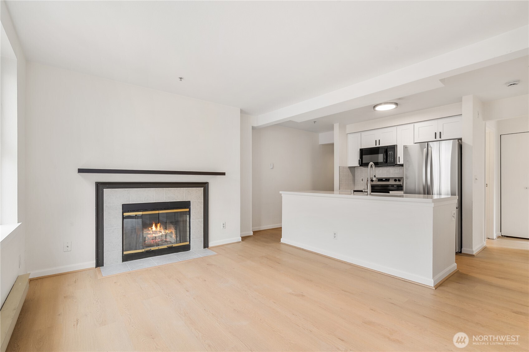 769 Hayes Street, Unit 405 Seattle, WA 98109 - Photo 7 of 29 a view of an empty room with kitchen and a fireplace