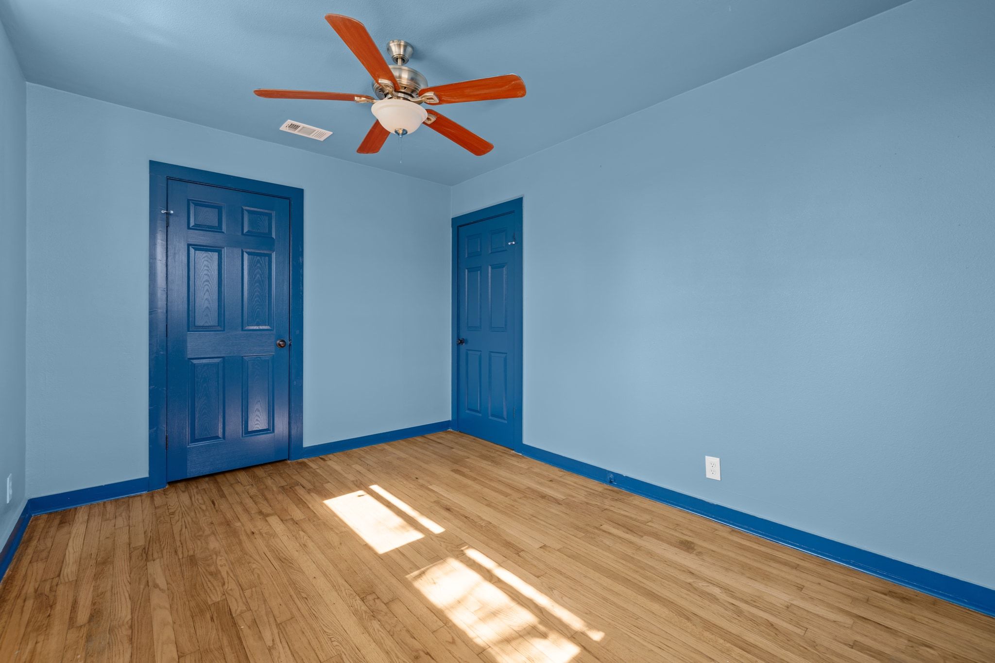 1181 Graham Street Austin, TX 78702 - Photo 12 of 27 a view of an empty room with wooden floor and a ceiling fan