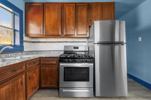 a kitchen with granite countertop white cabinets and stainless steel appliances