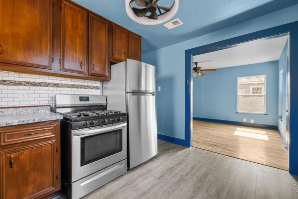 a kitchen with a stove a refrigerator and a cabinets