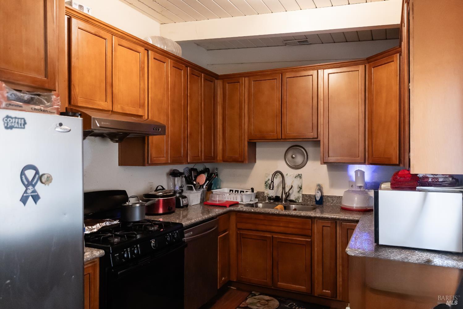 1500 Harrison Street Fairfield, CA 94533 - Photo 13 of 24 a kitchen with granite countertop cabinets and black appliances