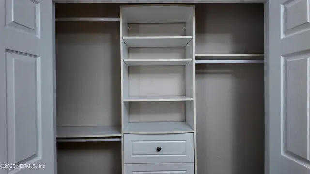 a view of walk in closet with empty racks