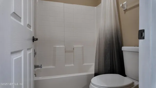 a white toilet and tub next to a bathroom sink