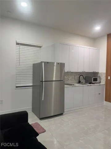 a kitchen with a refrigerator sink and cabinets