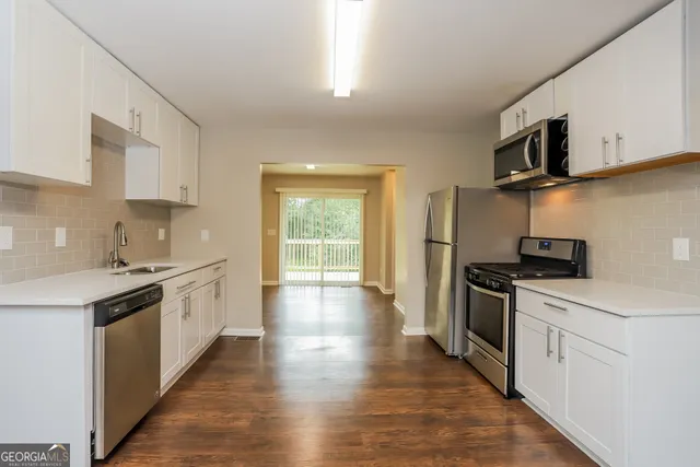 a kitchen with stainless steel appliances a sink dishwasher stove top oven and refrigerator