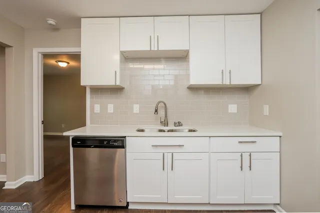a kitchen with white cabinets and sink