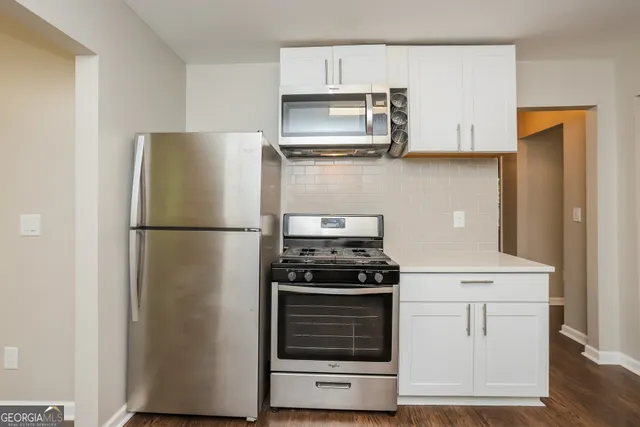 a kitchen with white cabinets and stainless steel appliances