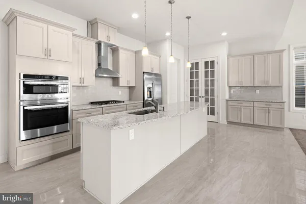 a kitchen with stainless steel appliances kitchen island granite countertop a stove and a refrigerator