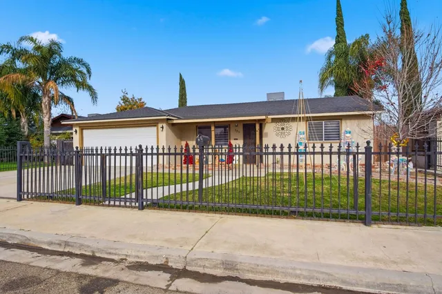 a view of a white house with a large windows and a yard