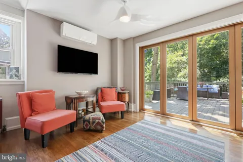 a living room with furniture a flat screen tv and a floor to ceiling window