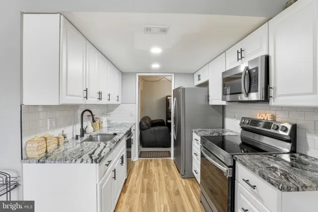 a kitchen with stainless steel appliances granite countertop a sink stove and refrigerator