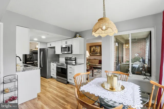a dining room with wooden floor a chandelier a wooden table and chairs