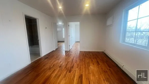 a view of a room with wooden floor and window