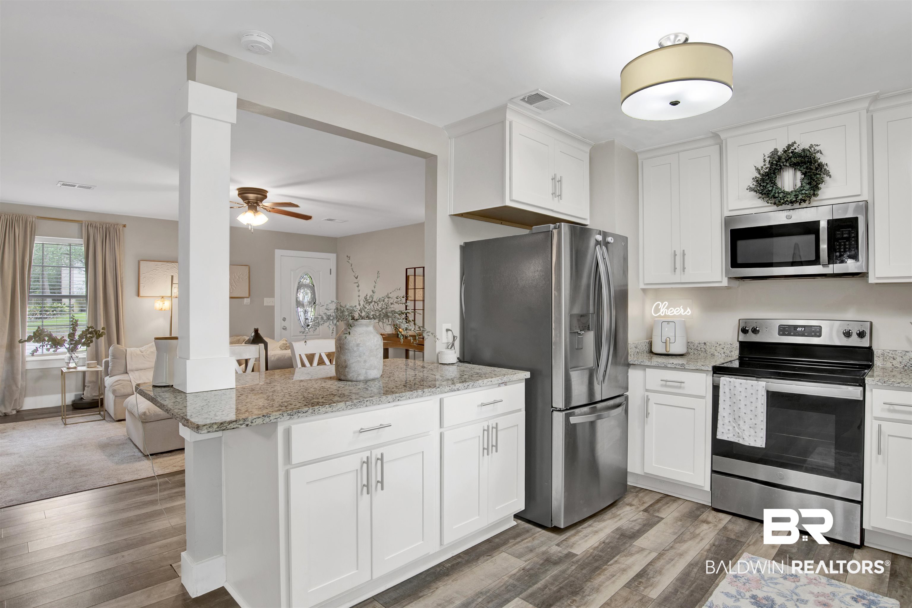 253 Maplewood Loop Daphne, AL 36526 - Photo 10 of 30 Kitchen featuring white cabinetry, granite countertops, stainless steel appliances, and wood-finish flooring