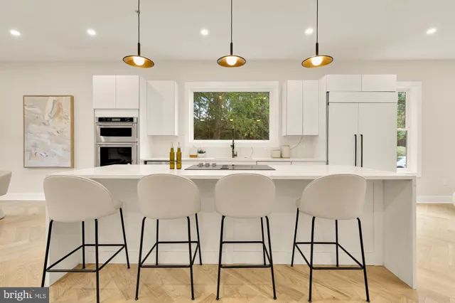 a large kitchen with kitchen island a sink appliances and a counter top space