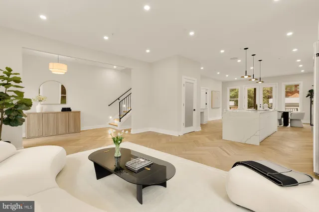 a kitchen with stainless steel appliances kitchen island granite countertop a stove a sink a dining table and chairs with wooden floor