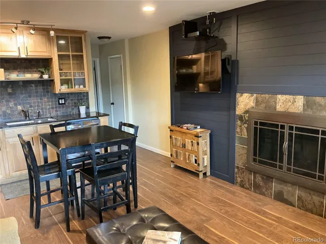 a kitchen with stainless steel appliances wooden cabinets dining table and chairs