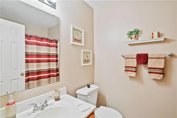 a bathroom with a sink mirror and toilet