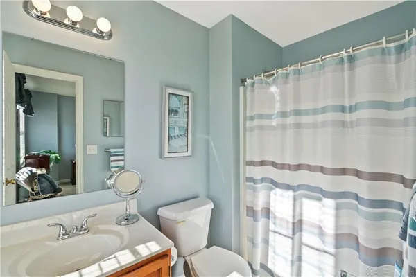 a bathroom with a sink mirror vanity and toilet