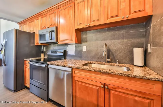 a kitchen with stainless steel appliances granite countertop a sink stove and refrigerator