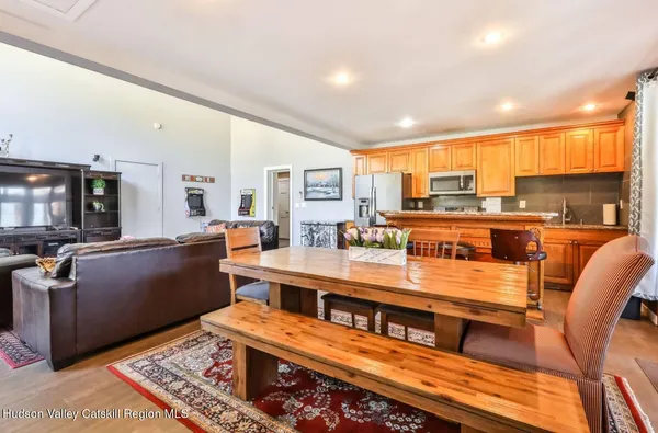 a large dining hall with stainless steel appliances granite countertop a barbecue counter and living room view