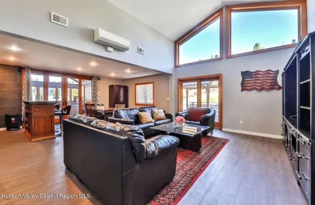 a living room with furniture a window and a flat screen tv