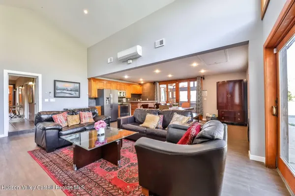 a living room with furniture kitchen view and a large window