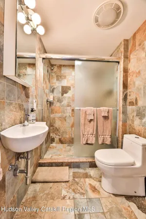a bathroom with a sink toilet and shower