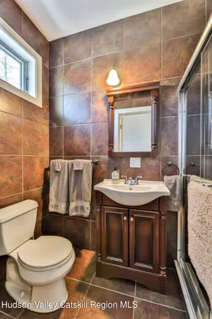 a bathroom with a granite countertop toilet and a sink