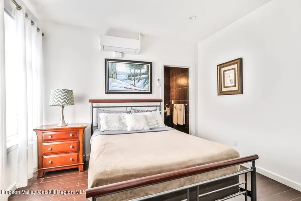 a bedroom with a bed and a painting on the wall