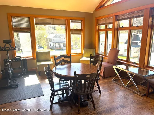 a view of a dining room with furniture large windows and wooden floor